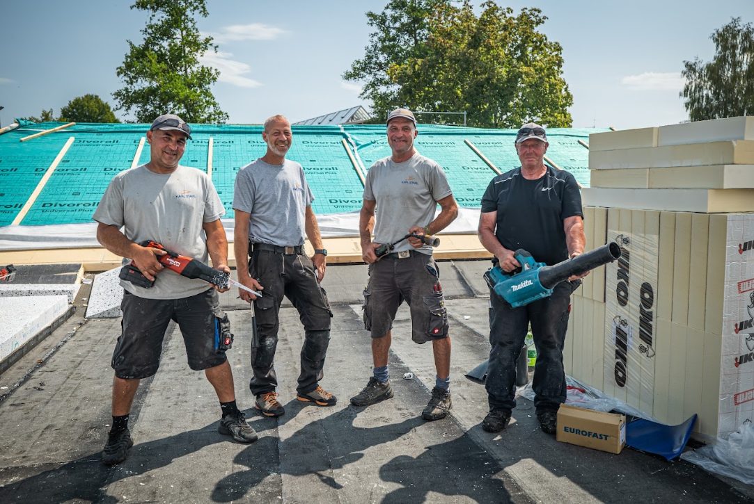 Vier Mitarbeitende von Karl Stahl Bedachungen im Gespräch auf einer Baustelle